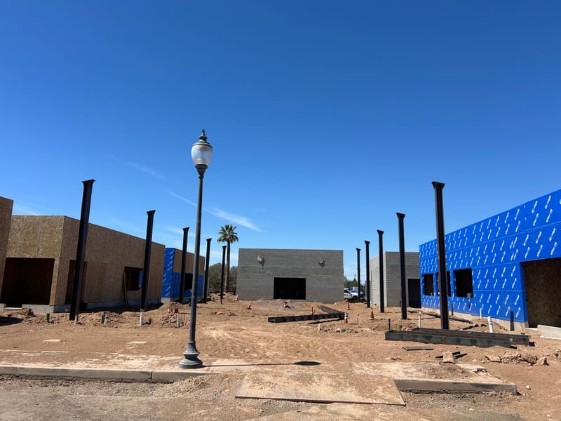 Concrete-block walls and standing steel columns across the Jefferson House site, April 2026